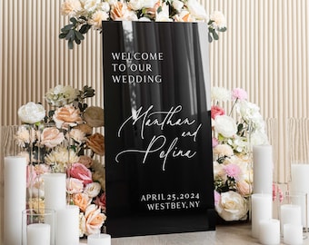 May include: Black acrylic wedding welcome sign with white text. The sign reads "Welcome to our wedding,  Marthan and Polina, April 25, 2024, Westbey, NY".