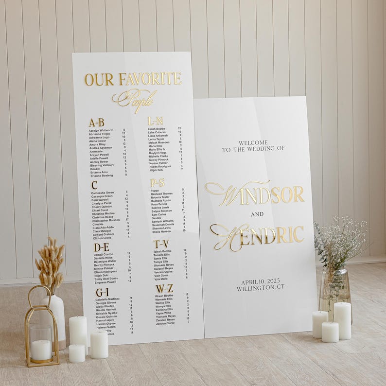 K&ouml;nnte beinhalten: Ein wei&szlig;es Schild mit goldenen Buchstaben, das eine Hochzeit f&uuml;r Windsor und Hendric ank&uuml;ndigt. Das Schild enth&auml;lt auch das Datum 10. April 2025 und den Ort Willington, CT. Ein zweites Schild listet die Namen der Hochzeitsg&auml;ste in alphabetischer Reihenfolge auf.