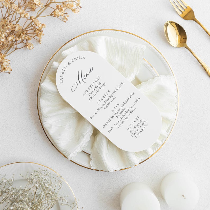 May include: A white menu card with rounded edges, featuring the names "LAUREN & ERICK" and the word "Menu" in elegant script. The menu lists appetizers, a starter, main courses, and dessert options. The card rests on a white napkin and a gold-rimmed plate.