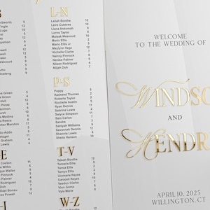 K&ouml;nnte beinhalten: Ein wei&szlig;er Hochzeitssitzplan mit goldenen Buchstaben. Der Plan listet die Namen der G&auml;ste in alphabetischer Reihenfolge auf. Die Namen sind in Abschnitte unterteilt, die mit A-B, L-N, P-S, T-V und W-Z gekennzeichnet sind. Der Plan enth&auml;lt auch den Text "Willkommen zur Hochzeit von Windsor und Hendric" sowie das Datum "10. April 2025" und den Ort "Willington, CT".