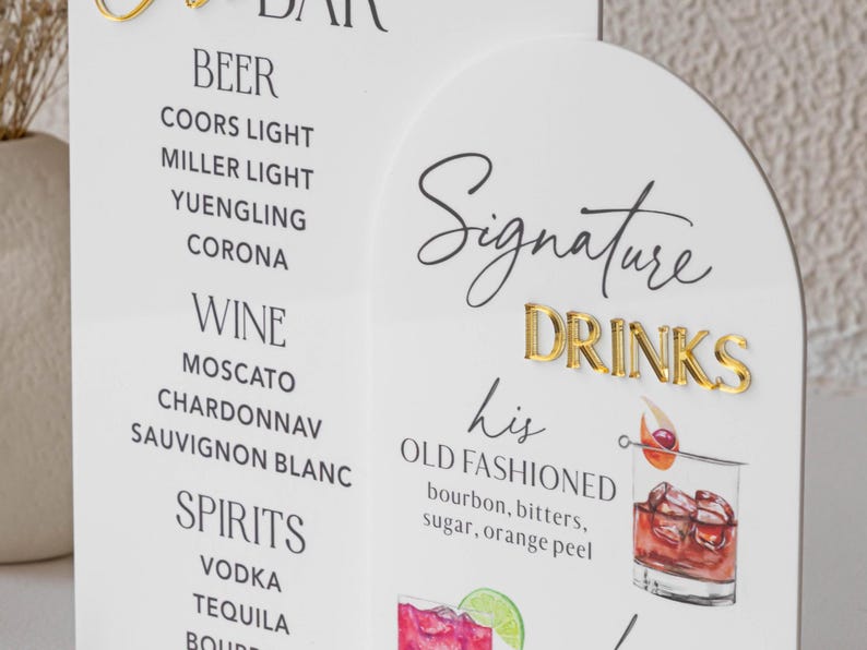 May include: A white bar menu with gold lettering and a list of drinks. The menu includes beer, wine, and spirits. The "Signature Drinks" section features an Old Fashioned cocktail illustration.