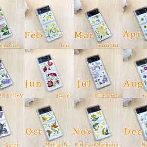 May include: Twelve phone cases with pressed flowers, each representing a different month of the year. The cases are clear and show the flowers pressed inside. The flowers are arranged in a vertical line on the case. The months are labeled on the cases, and the names of the flowers are listed below each case.