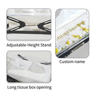May include: Clear tissue box with an adjustable-height stand. The box features the text "All the best" with gold hearts and yellow flowers. The long tissue box opening is visible.