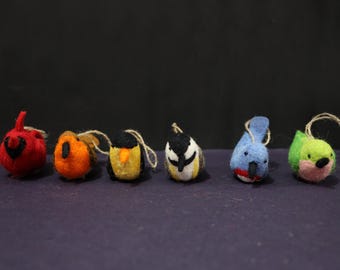 May include: Six felt bird ornaments in red, orange, black, yellow, blue, and green. Each bird has a string for hanging. The ornaments are handmade and have a whimsical design, perfect for holiday decor.