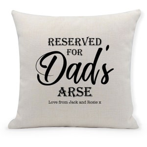 May include: A white cushion with black text that reads "RESERVED FOR Dad's ARSE Love from Jack and Rosie x".