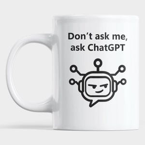 May include: A white ceramic mug featuring the black printed text "Don't ask me, ask ChatGPT" above a black line-art graphic of a stylised robot head with antenna-like nodes, centred on the front of the cylindrical vessel.