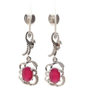 Peut inclure: Paire de boucles d'oreilles pendantes en argent avec des pierres précieuses ovales rouge rubis. Les boucles d'oreilles présentent un motif de filigrane décoratif autour des pierres et un accent incurvé avec de petites pierres claires.
