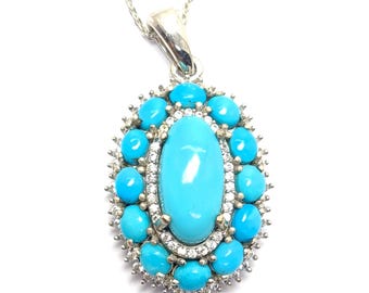 May include: A silver pendant necklace featuring an oval turquoise stone surrounded by smaller turquoise stones and clear crystals. The pendant hangs from a delicate silver chain, creating a striking jewelry piece.