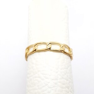 K&ouml;nnte beinhalten: Ein goldener Kettenring mit schlichtem Design. Der Ring besteht aus einer dicken, massiven Kette.