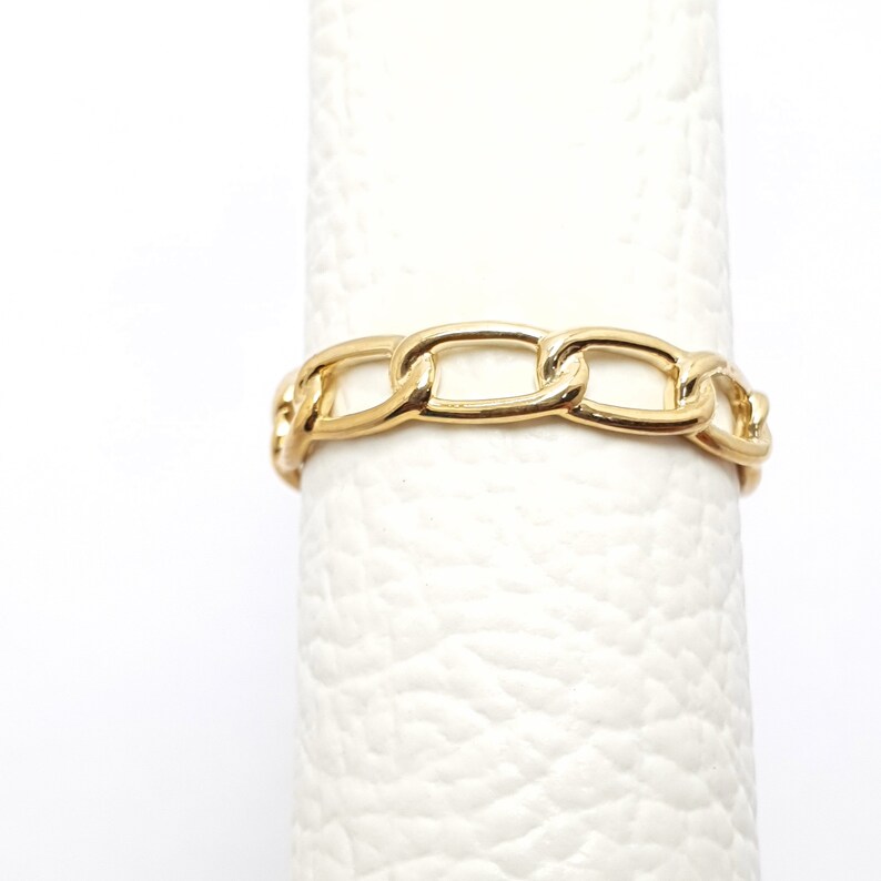 K&ouml;nnte beinhalten: Ein goldener Kettenring mit einem dicken, klobigem Design. Der Ring besteht aus einem einzigen Kettenglied, das sich um die gesamte Band wiederholt.