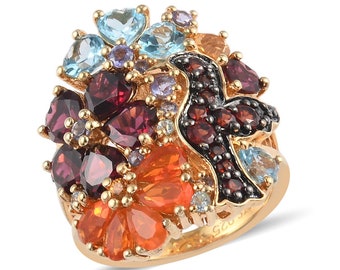 May include: A gold ring with a colorful gemstone design. The ring features a bird shape with red, orange, blue, and purple gemstones. The ring is set with a variety of gemstones, including garnets, opals, and topaz.