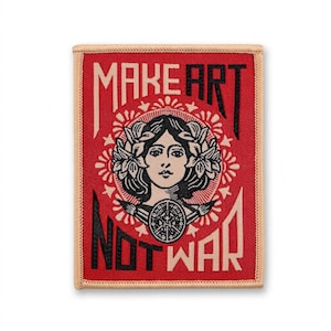 Könnte beinhalten: Rechteckiger Aufnäher mit rotem Hintergrund und cremefarbenem Rand. Er zeigt eine Illustration eines Frauengesichts, umgeben von floralen Elementen. Der schwarze Text lautet "MAKE ART NOT WAR".