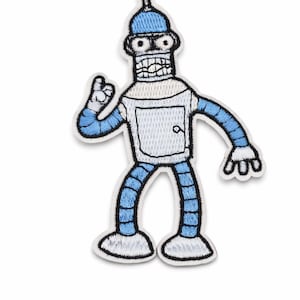 Op de afbeelding: Geborduurde patch met een cartoon robot karakter in blauw, wit en zwart. De robot heeft een doosvormige romp met een deur, blauwe armen en benen en een ronde kop. De patch heeft een witte rand.