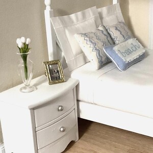 a white bed sitting on top of a wooden shelf
