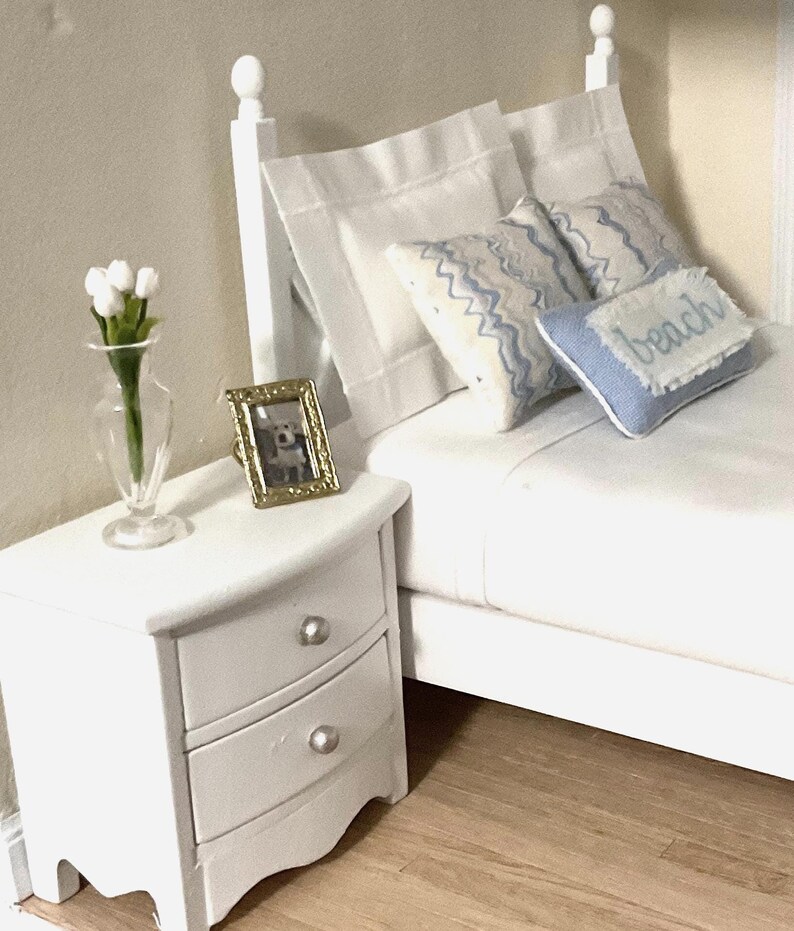 a white bed sitting on top of a wooden shelf