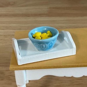 a small table with a bowl of lemons on it