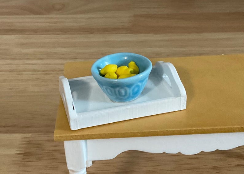 a small table with a bowl of lemons on it