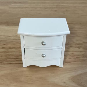a small white table with a drawer on top of it