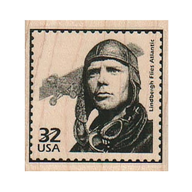 May include: A vintage-style rubber stamp featuring a black and white image of Charles Lindbergh, a famous aviator, wearing a leather flight helmet and goggles. The stamp also includes a black and white image of an airplane in the background. The stamp is labeled "32 USA" and "Lindbergh Flies Atlantic".