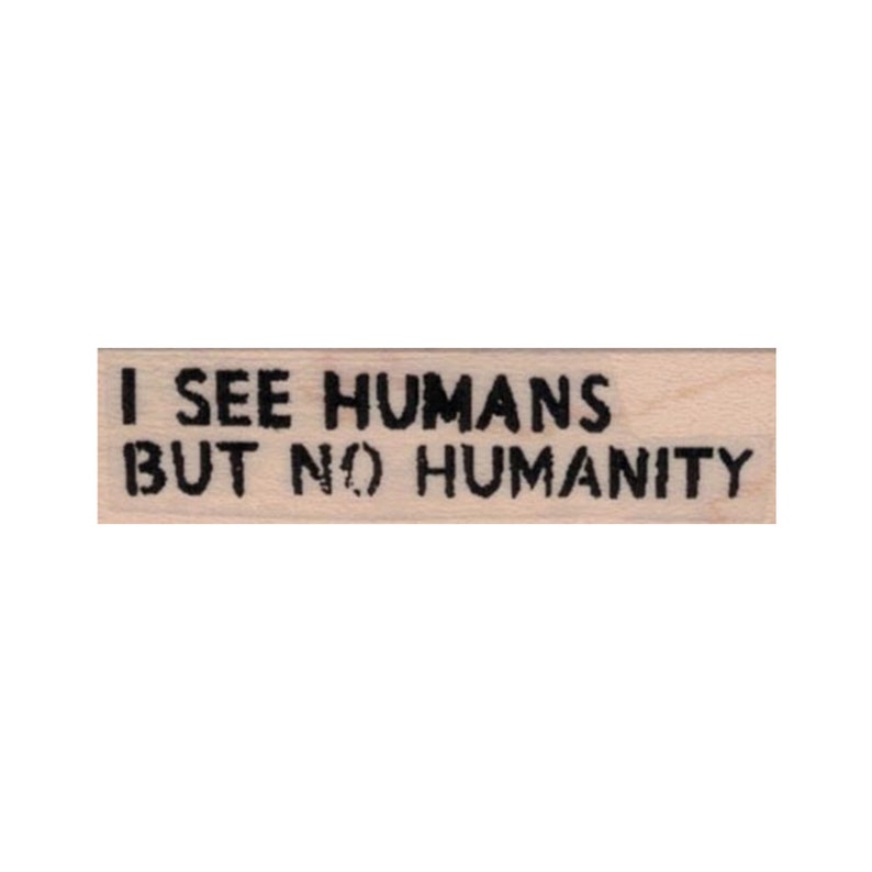 May include: A wooden stamp with the text "I see humans but no humanity" in black ink.
