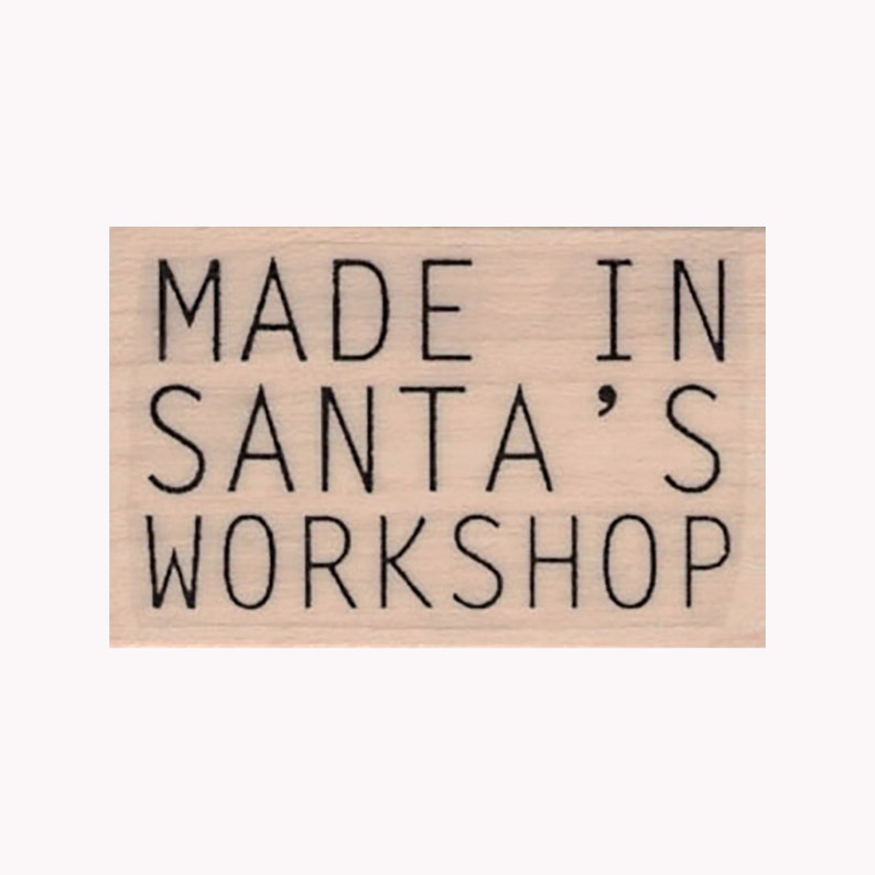 May include: A wooden stamp with the text "MADE IN SANTA'S WORKSHOP" in black lettering.