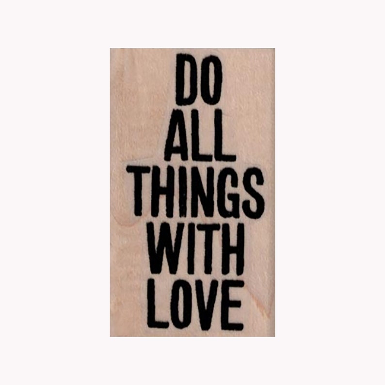 May include: A wooden stamp with the text "Do all things with love" in black lettering.