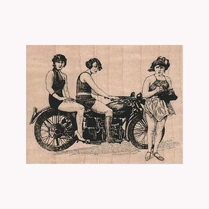 Peut inclure: Trois femmes en maillot de bain vintage posent avec une moto. Une femme est assise sur la moto, une autre est debout derrière elle et la troisième femme est debout sur le côté. La moto est noire et a un side-car.