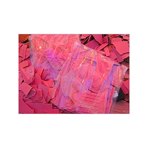May include: A large pile of pink paper scraps, some of which are wrapped in clear plastic.