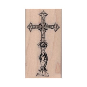 May include: A wooden rubber stamp featuring a detailed black and white illustration of a cross with an angel at the base.