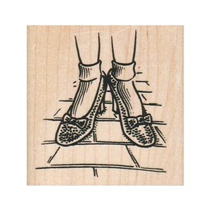 May include: A pair of black shoes with bows on the toes, worn with white socks. The shoes are on a brick-like surface.