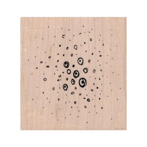 Op de afbeelding: Een abstracte zwart-witte tekening van een cluster van cirkels op een lichtbruine houten achtergrond.