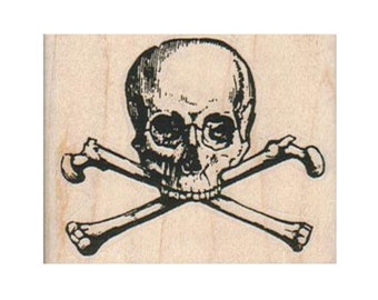 May include: A black and white rubber stamp featuring a skull and crossbones design. The skull has a detailed face with eye sockets and a mouth.