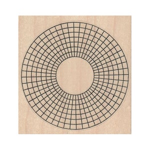 May include: A wooden stamp with a circular design. The design is a grid of squares that radiate out from the center, creating a sunburst effect.