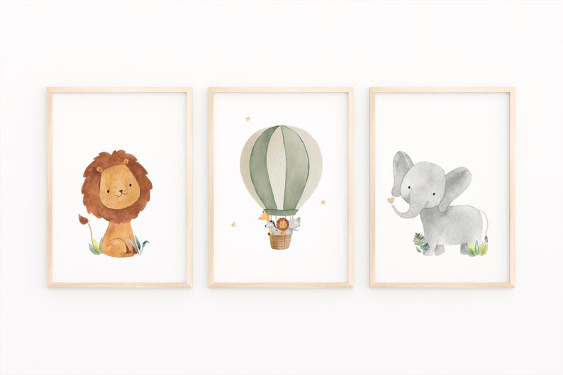 May include: Set of three framed watercolor art prints featuring a lion, an elephant, and a hot air balloon. The lion has a brown mane, the elephant is gray, and the balloon is green and white. The prints are in light wood frames.