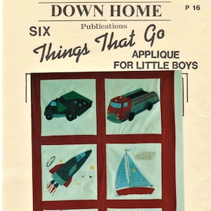 May include: A vintage applique pattern for a quilt featuring six different vehicles for little boys. The pattern includes a fire engine, rocket ship, dump truck, train, sail boat, and airplane. The pattern is printed on a light beige paper with a red border.
