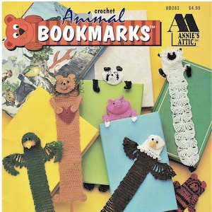 May include: Crochet animal bookmarks pattern book. The cover features a variety of crocheted bookmarks, including a lion, a pig, an eagle, a bird, a dog, and a sheep. The title of the book is "Animal Bookmarks" and the publisher is Annie's Attic.