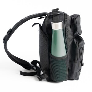 May include: Black tactical backpack with a mesh water bottle holder and a green water bottle inside.