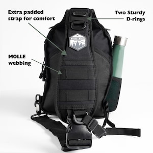May include: Black tactical sling bag with adjustable padded strap, MOLLE webbing, and two D-rings. The bag has a Whiskey Woods logo patch and a side pocket.