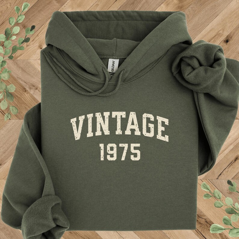 May include: A green hooded sweatshirt with the text "Vintage 1975" in white.