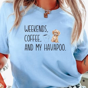 May include: Light blue t-shirt with the text "WEEKENDS, COFFEE, AND MY HAVAPOO." A graphic of a coffee cup and a small brown dog are also on the shirt.