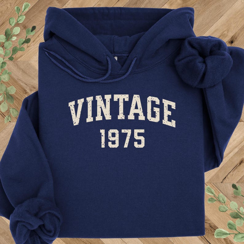 May include: A navy blue hoodie with a white vintage 1975 graphic.