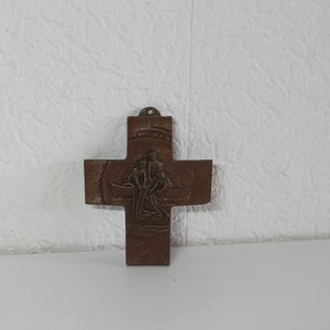 Könnte beinhalten: Ein bronzenes Kreuz mit einem detaillierten Design eines Baumes und Blumen. Das Kreuz ist ein religiöses Symbol und wäre eine großartige Ergänzung für eine Wohnkultur-Kollektion.