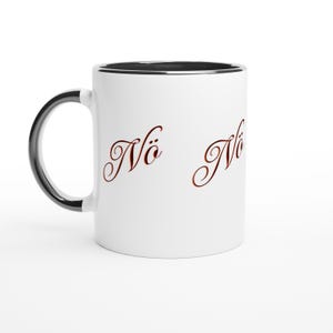 Op de afbeelding: Witte keramische mok met een zwarte handgreep en rand. De mok heeft het woord "Nö" in een decoratief, roodbruin schrift op de voorkant. De mok staat tegen een witte achtergrond.