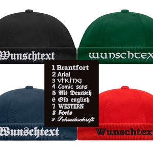 Könnte beinhalten: Vier verschiedene farbige Beanies mit dem Wort "Wunschtext" in weiß vorne aufgestickt. Die Mützen sind schwarz, grün, dunkelblau und rot.