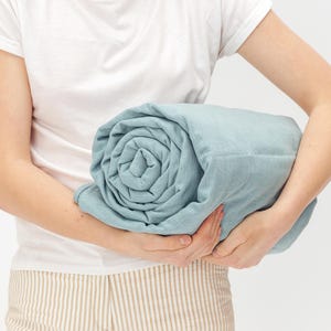 Women holding blue color weighted blanket