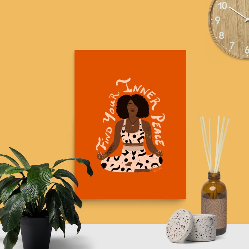 May include: An orange art print featuring a woman in a yoga pose with the text "Find Your Inner Peace." The woman is wearing a patterned top and bottoms. A clock, a plant, and a diffuser are in the background.