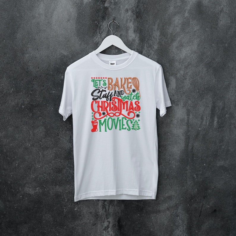 Pu&ograve; includere: Maglietta bianca con una grafica verde e rossa che dice "Let's Bake Stuff and Watch Christmas Movies".