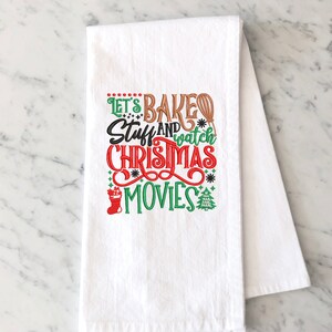 Pu&ograve; includere: Asciugamano da cucina bianco con ricamo rosso, verde e marrone che dice "Let's Bake Stuff and Watch Christmas Movies".