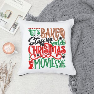 Pu&ograve; includere: Cuscino bianco con testo ricamato che recita "Let's Bake Stuff and Watch Christmas Movies". Il testo &egrave; in rosso, verde, marrone e bianco. Sul cuscino sono presenti un piccolo albero di Natale e una calza ricamati.