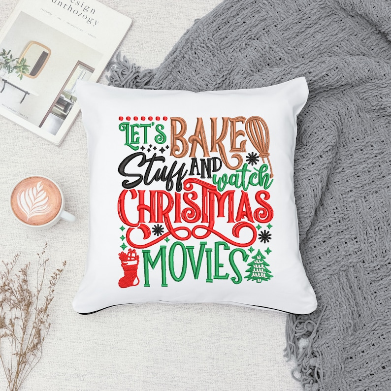 Pu&ograve; includere: Cuscino bianco con testo ricamato che recita "Let's Bake Stuff and Watch Christmas Movies". Il testo &egrave; in rosso, verde, marrone e bianco. Sul cuscino sono presenti un piccolo albero di Natale e una calza ricamati.